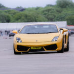 a Lamborghini driving around a race track for 6th Gear Experience